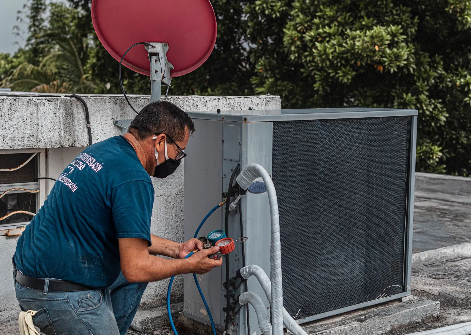An engineer checking an air conditioning unit with pressure gauges